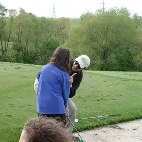 Charles Kallassy teaching a Special Olympics golfer